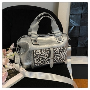 Detail of silver crocodile texture handbag with leopard print pocket and wide strap