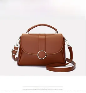 Detail view of the vintage brown leather bag with silver ring buckle and top handle