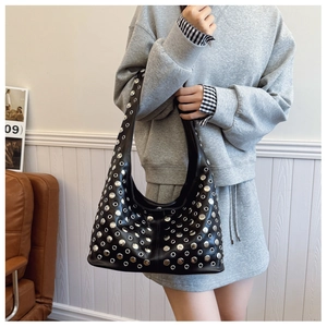 Détail du sac à bandoulière punk noir avec clous ronds argentés et œillets métalliques