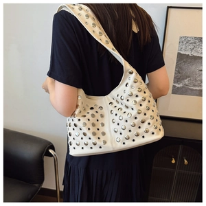 Détail du sac Hobo blanc en cuir avec clous et œillets métalliques sur modèle