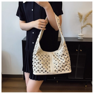 Détail du sac hobo crème avec rivets argentés et œillets métalliques en cuir mat