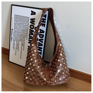 Gros plan d'un sac hobo marron avec des rivets argentés et des détails d'œillets