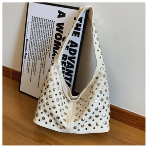 Détails d'un sac Hobo en cuir blanc orné de clous ronds en métal argenté tendance