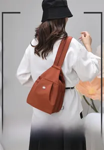 Dettaglio della borsa a tracolla color caramello con texture morbida e zip funzionali