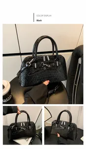 Detail of black crocodile texture handbag with silver hardware and double zippers