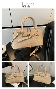 Detail view of khaki crocodile embossed handbag with silver buckle and shoulder strap