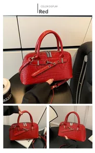 Detailed view of red crocodile-embossed leather handbag with silver hardware and zipper