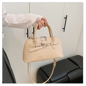 Detail of cream faux crocodile texture and silver metal lock on a handbag
