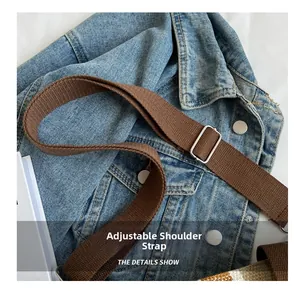Detail of adjustable woven brown shoulder strap with silver buckle on canvas tote bag