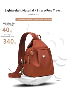 Dettaglio della borsa a tracolla leggera in nylon rosso-marrone da 340g su piume bianche morbide
