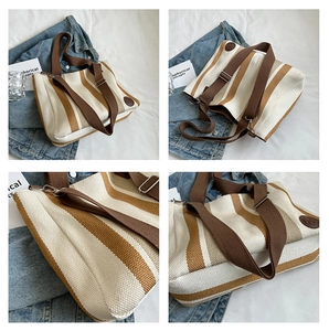Detail view of striped canvas tote bag with brown straps and adjustable crossbody strap