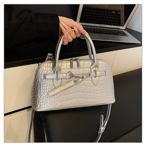 Close-up of silver croc-embossed handbag with dual handles and metal buckle detail