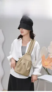 Primo piano di uno zaino oxford kaki indossato come borsa a tracolla da una modella