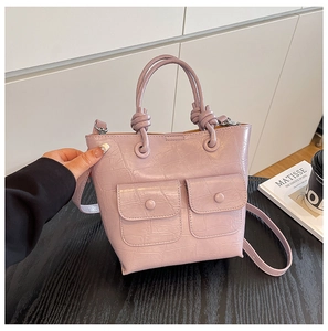 Lavender faux crocodile handbag with double front flap pockets and a knotted handle detail