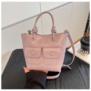 Detail of lilac crocodile embossed tote bag with dual front pockets and top handle