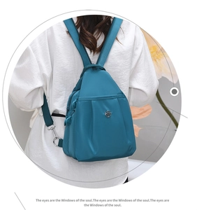 Dettaglio mini zaino in nylon blu con tasche con zip e logo in metallo decorativo