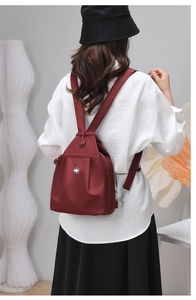 Dettaglio dello zaino bordeaux in tessuto oxford con coulisse e tasca laterale zip