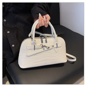 Detailed macro view of white crocodile embossed texture on a leather tote with silver hardware