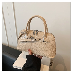 Close-up of beige crocodile pattern handbag featuring metal buckles and dual zippers