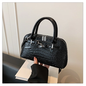 Detail of black crocodile texture handbag with dual silver metal zippers and round handle