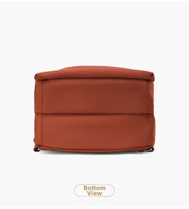 Vista dettagliata del fondo dello zaino in nylon rosso mattone con cuciture e trama fitta