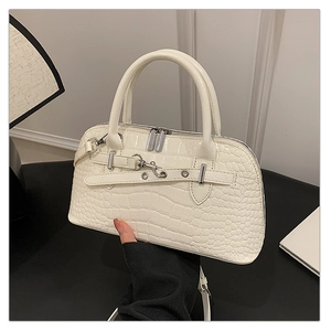 Detail view of white crocodile pattern shell bag with silver buckles and handle