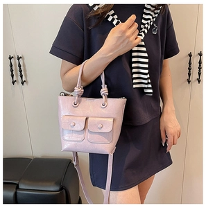 Lilac crocodile embossed tote bag featuring dual front flap pockets and knot handle detail