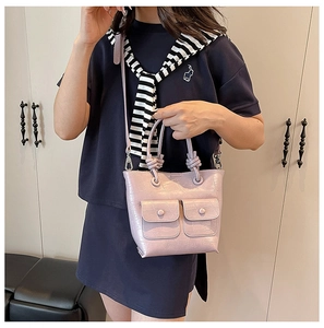 Detail of lavender crocodile pattern bag with front buckle pockets and knotted handle