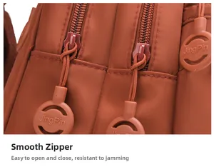 Dettaglio della cerniera scorrevole e texture in nylon su un mini zaino marrone moda