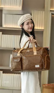 Detail showing the large capacity brown leather travel bag with durable woven handles