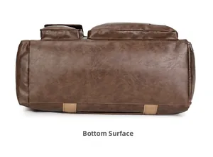 Detail view of large brown leather travel bag bottom with reinforced woven straps