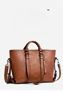 Makro-Detail von braunem Leder mit Kieselstruktur und Metallreißverschluss am Shopper