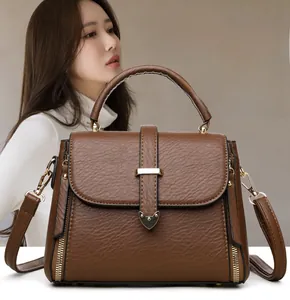 Sac à main marron en cuir grainé avec détails dorés en forme de cœur et bandoulière