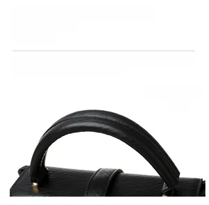 Détail d'un sac à main en cuir noir avec poignées solides et boucles dorées chic