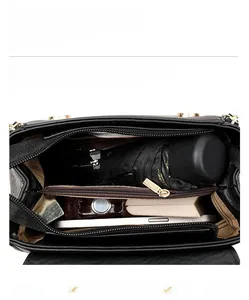 Vue intérieure du sac bandoulière en cuir noir montrant les compartiments grande capacité