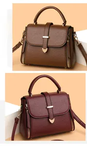 Détail de grands sacs cabas en cuir grainé marron et bordeaux avec ferrures dorées