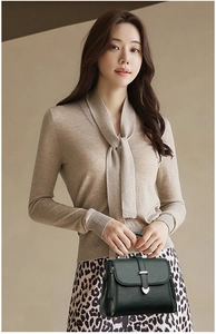 Détail du sac à main en cuir grainé vert foncé avec boucle en métal et zip latéral