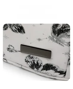 Close-up of butterfly print detail and black metal ornament on the white leather backpack