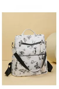 Detail of white butterfly print backpack with fringe charm and star pattern texture