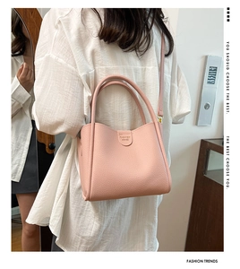 Détail du sac seau en cuir litchi rose avec finitions dorées et logo FASHION GRACE