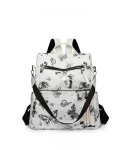 Front view of white butterfly print backpack with tassel and adjustable black straps