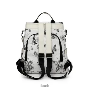 Rear view of white butterfly print backpack showing anti-theft back pocket and straps