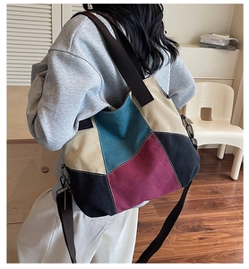Detail of color-block canvas tote bag with adjustable strap worn by a model