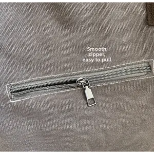 Macro shot of smooth silver metal zipper on durable gray canvas tote bag detail