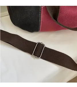 Detail of adjustable brown shoulder strap with silver buckle on canvas tote bag