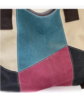 Detail of color-block canvas tote bag showing weave texture and reinforced white stitching