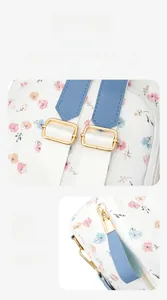 Detail of backpack showing adjustable shoulder straps and golden metal zippers with floral print