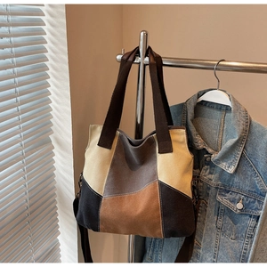 Close-up of color-block canvas tote bag with adjustable shoulder strap and durable handles
