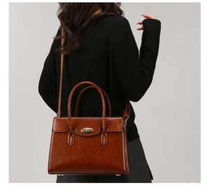 Detailed back view of vintage brown leather handbag with gold twist lock for women