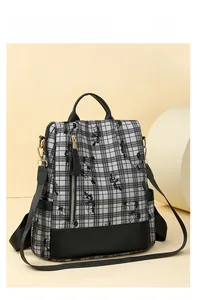 Detail of plaid nylon backpack featuring floral prints and vertical front zipper pocket